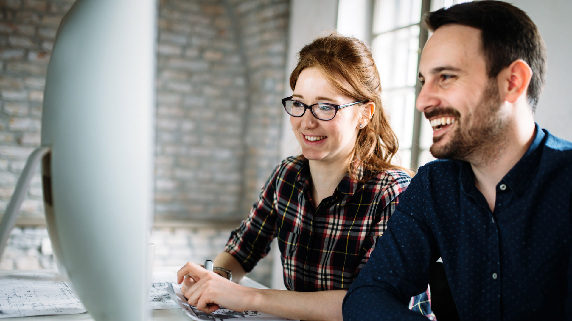 IT co-workers collaborating on a project in an industrial building