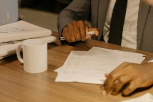 Business owner reviewing cyber insurance renewal questions on a paper application at a desk