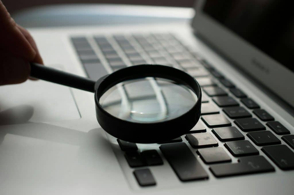 The 30-Minute Monthly IT Maintenance Checklist for Small Business 1 magnifying glass near gray laptop computer